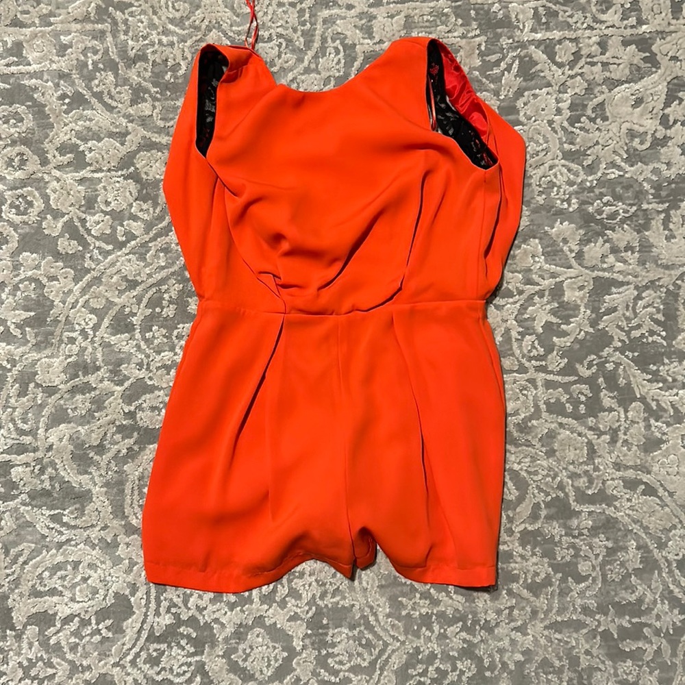 Red orange romper with lace back and cowl back. Zip closure.